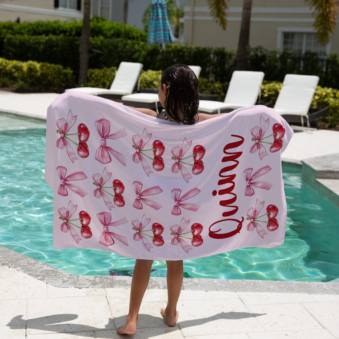 Coquette Bows and Cherry Beach Towel Personalized For Girls - Girls standing next to pool with her Pink Coquette Beach Towel