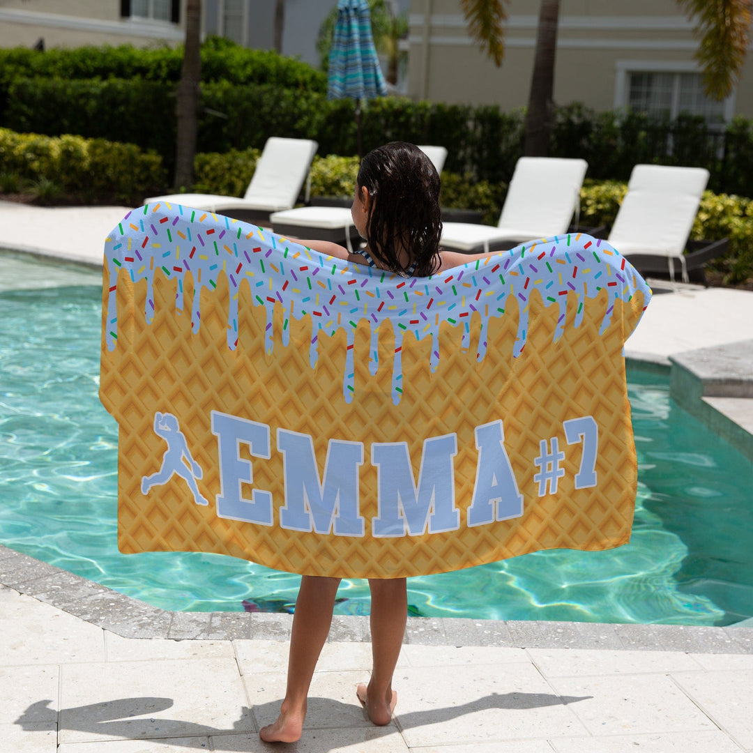 Ice Cream Drip Softball Personalized Beach Towel - Blue with a girl holding the towel next to the pool